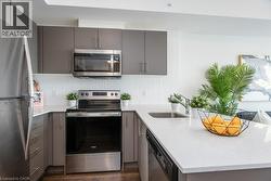 Kitchen featuring stainless steel appliances, white quartz countertops - 