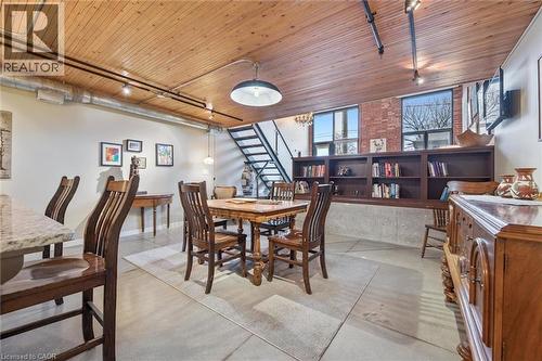 Dining space featuring concrete floors, wood ceiling, and track lighting - 85 Spruce Street Unit# 106, Cambridge, ON - Indoor Photo Showing Dining Room