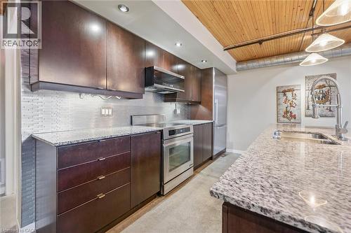 Kitchen with wood ceiling, stainless steel appliances, light stone counters, and dark wood finish cabinetry - 85 Spruce Street Unit# 106, Cambridge, ON - Indoor Photo Showing Kitchen With Double Sink With Upgraded Kitchen