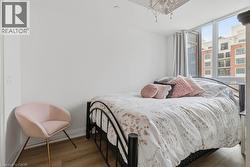 Bright room featuring expansive windows, wood-finish flooring, and a decorative ceiling light fixture - 
