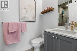 Ensuite Bathroom featuring a grey vanity with quartz countertop, an undermount sink, and a stunning walk in shower - 