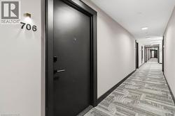 Entrance door with modern hardware, illuminated by a wall-mounted light fixture - 