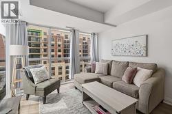 Floor-to-ceiling windows with roller shades frame the living space - 