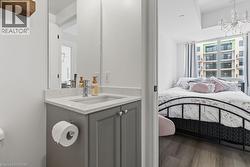 Bathroom vanity with a light gray cabinet, quartz countertop, and stainless steel faucet - 