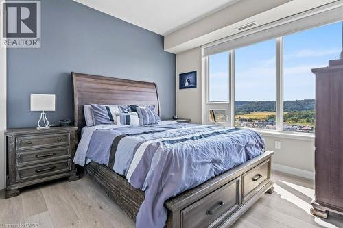 Bedroom featuring light wood-type flooring and baseboards - 385 Winston Road Unit# 1402, Grimsby, ON - Indoor Photo Showing Bedroom