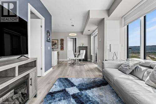 Living area featuring light wood-style flooring and baseboards - 385 Winston Road Unit# 1402, Grimsby, ON - Indoor Photo Showing Living Room