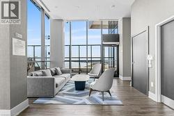 Living room with floor to ceiling windows and wood finished floors - 