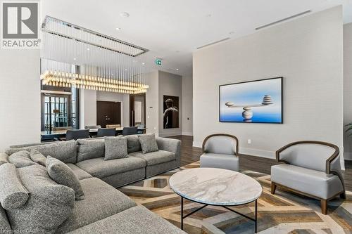 Living area featuring a high ceiling, wood finished floors, and recessed lighting - 385 Winston Road Unit# 1402, Grimsby, ON - Indoor Photo Showing Living Room