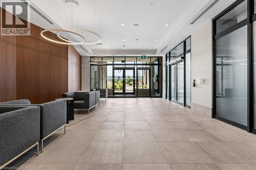 Community lobby featuring floor to ceiling windows, wooden walls, and recessed lighting - 385 Winston Road Unit# 1402, Grimsby, ON - Indoor Photo Showing Other Room