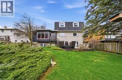The property features an extensive backyard with a well-maintained lawn and mature shrubs - 