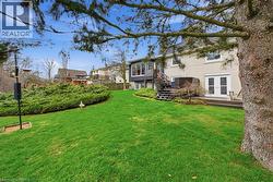 The property features an extensive lawn area, mature trees, and well-maintained shrubbery - 