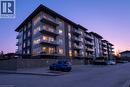 Modern multi-story building featuring extensive glazing, private balconies with glass railings, and a stone-clad retaining wall - 16 Markle Crescent Unit# 111, Ancaster, ON  - Outdoor With Facade 