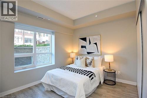 Light-toned wood-finish flooring complements neutral wall tones and white baseboards - 16 Markle Crescent Unit# 111, Ancaster, ON - Indoor Photo Showing Bedroom