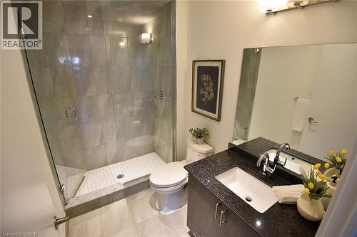 Bathroom featuring a glass-enclosed shower with large format wall tiles and a white mosaic tile pan - 16 Markle Crescent Unit# 111, Ancaster, ON - Indoor Photo Showing Bathroom
