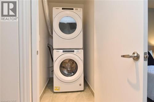 Dedicated laundry closet featuring a stacked white front-load washer and dryer - 16 Markle Crescent Unit# 111, Ancaster, ON - Indoor Photo Showing Laundry Room