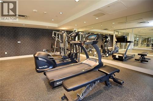 Fitness center featuring rubber flooring, recessed lighting, mirrored walls, and a patterned accent wall - 16 Markle Crescent Unit# 111, Ancaster, ON - Indoor Photo Showing Gym Room