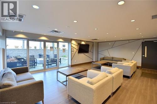 Spacious common area featuring wood-finish flooring, recessed lighting, and a modern accent wall - 16 Markle Crescent Unit# 111, Ancaster, ON - Indoor Photo Showing Living Room