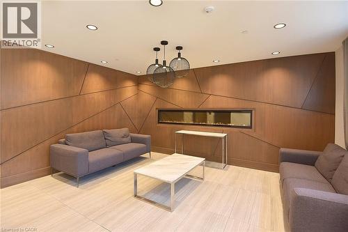 Feature wall with geometric wood-finish paneling and an elongated electric fireplace - 16 Markle Crescent Unit# 111, Ancaster, ON - Indoor
