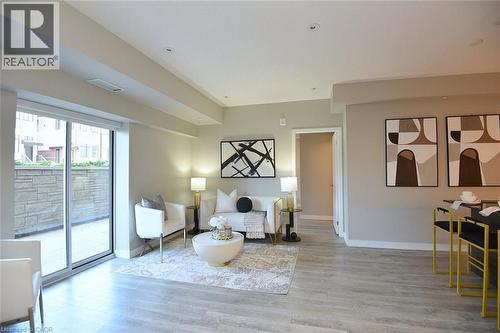 Open-concept living space featuring wood-finish flooring, recessed lighting, and a sliding glass door providing outdoor access - 16 Markle Crescent Unit# 111, Ancaster, ON - Indoor Photo Showing Living Room