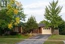 View of property hidden behind natural elements featuring brick siding, driveway, and an attached garage - 32 Donly Drive N, Simcoe, ON  - Outdoor 