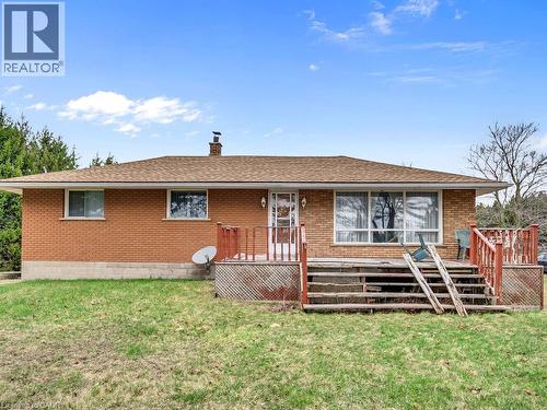 Brick exterior with multiple windows and a brown shingle roof - 1416 Highway 6, Hamilton, ON - Outdoor With Deck Patio Veranda