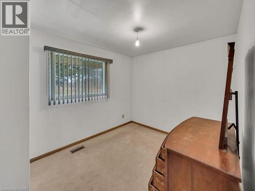 Bright room featuring a single window with vertical blinds, a ceiling-mounted light fixture, and neutral carpeting - 1416 Highway 6, Hamilton, ON - Indoor Photo Showing Other Room