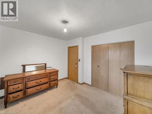 Neutral wall finishes with a ceiling-mounted light fixture, wood-finish interior door, and dual wood-finish closet doors - 1416 Highway 6, Hamilton, ON - Indoor