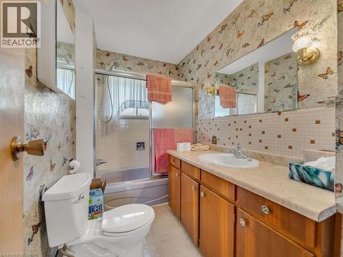Bathroom featuring a single vanity with wood-finish cabinetry, a white drop-in sink, and a light-toned countertop - 1416 Highway 6, Hamilton, ON - Indoor Photo Showing Bathroom