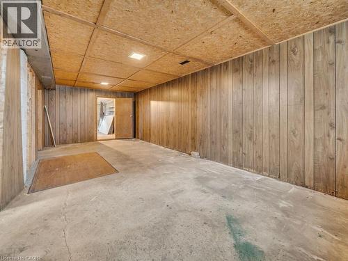 Room featuring wood-paneled walls, a concrete floor, and an exposed ceiling with recessed lighting - 1416 Highway 6, Hamilton, ON - Indoor