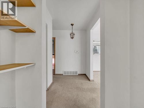 Neutral wall paint, built-in shelving, and a hanging light fixture - 1416 Highway 6, Hamilton, ON - Indoor Photo Showing Other Room