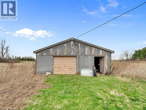 Utility building with a gable roof, roll-up door, and an additional side entrance - 1416 Highway 6, Hamilton, ON - Outdoor