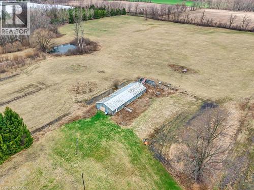 Expansive agricultural land featuring a lengthy outbuilding, a natural pond, and scattered mature trees - 1416 Highway 6, Hamilton, ON - Outdoor With View