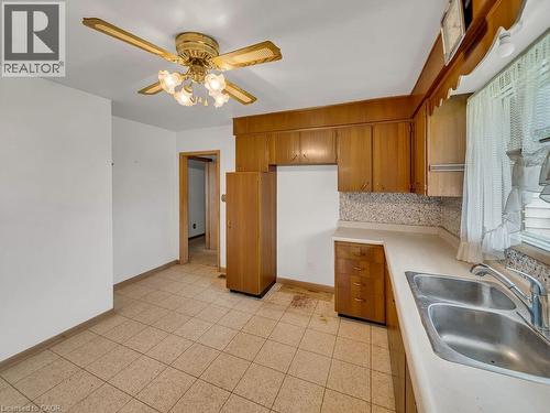 Kitchen featuring wood cabinetry, laminate countertops, and a double basin stainless steel sink - 1416 Highway 6, Hamilton, ON - Indoor Photo Showing Kitchen With Double Sink
