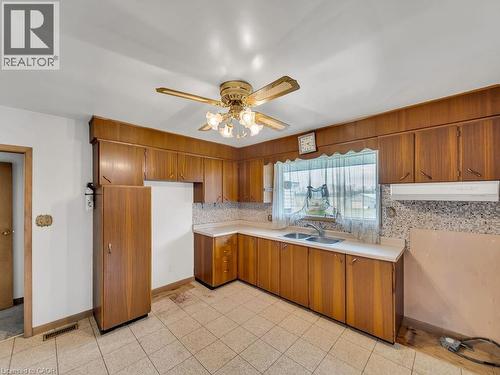 Kitchen featuring wood-finish cabinetry, tile flooring, and a double basin sink - 1416 Highway 6, Hamilton, ON - Indoor Photo Showing Kitchen With Double Sink