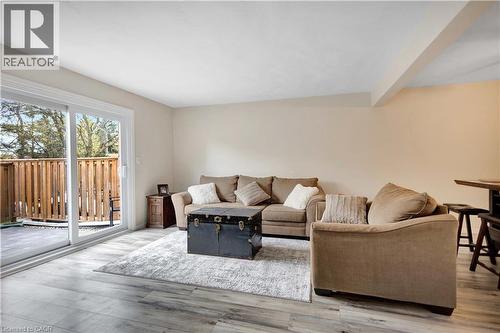 Spacious living area featuring light wood-finish flooring, neutral wall tones, and a large sliding glass door - 32 Montclair Crescent, Simcoe, ON - Indoor Photo Showing Living Room