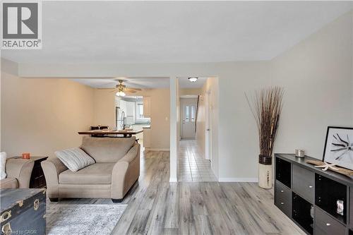 Living area featuring wood-finish flooring, a neutral color palette, and an open entryway to the kitchen - 32 Montclair Crescent, Simcoe, ON - Indoor Photo Showing Living Room
