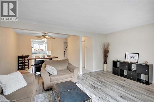 Open-concept living space featuring wood-finish flooring, neutral wall tones, and overhead lighting - 32 Montclair Crescent, Simcoe, ON - Indoor Photo Showing Living Room