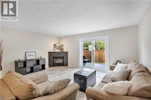 Living area featuring light wood-finish flooring, a dark mantel and fireplace, and recessed lighting - 32 Montclair Crescent, Simcoe, ON - Indoor Photo Showing Living Room With Fireplace