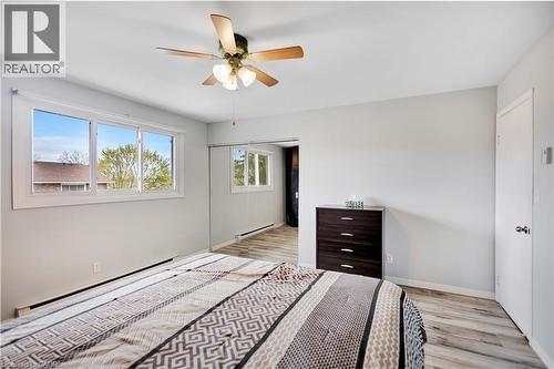 Spacious room featuring light gray walls, light wood-finish flooring, and a ceiling fan with integrated lighting - 32 Montclair Crescent, Simcoe, ON - Indoor Photo Showing Bedroom