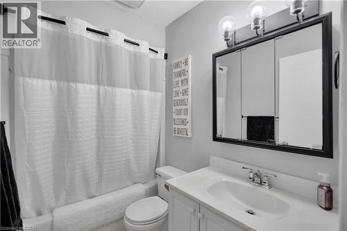Bathroom featuring a white vanity with integrated sink, chrome faucet, and a black-framed medicine cabinet - 32 Montclair Crescent, Simcoe, ON - Indoor Photo Showing Bathroom