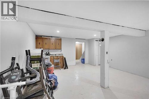 Spacious lower-level area featuring white walls, exposed ceiling beams, and recessed lighting - 32 Montclair Crescent, Simcoe, ON - Indoor