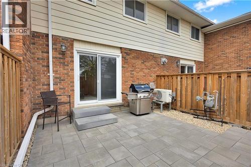 Rear patio featuring large format paver stones, a sliding glass door entry, and brick and siding exterior - 32 Montclair Crescent, Simcoe, ON - Outdoor With Deck Patio Veranda With Exterior