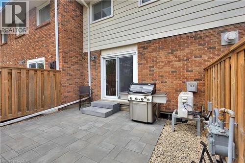 Paver patio featuring a two-step entry, brown privacy fencing, and a white sliding glass door - 32 Montclair Crescent, Simcoe, ON - Outdoor With Deck Patio Veranda With Exterior