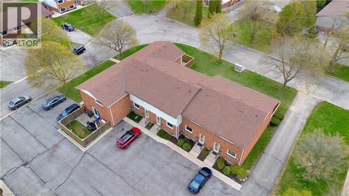 Multi-unit brick structure with gabled roofs, individual entranceways, paved parking areas, and landscaped shrubbery - 32 Montclair Crescent, Simcoe, ON - Outdoor With View