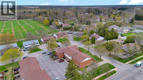 Aerial perspective showcasing multiple residential buildings with brick and siding exteriors, surrounded by established trees and green spaces - 32 Montclair Crescent, Simcoe, ON - Outdoor With View