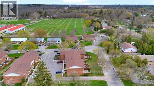 Aerial perspective highlighting multiple residential buildings with brick exteriors and shingle roofs - 32 Montclair Crescent, Simcoe, ON - Outdoor With View