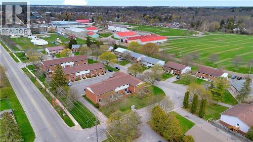 Aerial perspective showcasing a residential development with multiple brick-clad townhome-style buildings - 32 Montclair Crescent, Simcoe, ON - Outdoor With View