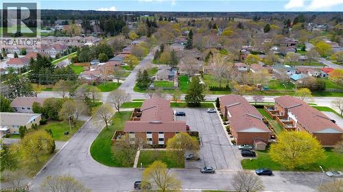Aerial perspective showcasing a residential community with numerous detached homes and multi-unit buildings - 32 Montclair Crescent, Simcoe, ON - Outdoor With View