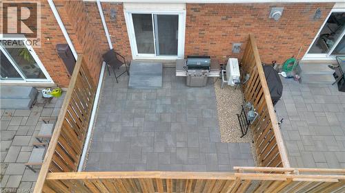 Paved patio area featuring brick exterior walls and white-framed sliding glass doors - 32 Montclair Crescent, Simcoe, ON - Outdoor With Deck Patio Veranda With Exterior
