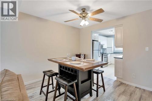 Dining area featuring wood-finish flooring, a ceiling fan with integrated lighting, and an open entryway to the kitchen - 32 Montclair Crescent, Simcoe, ON - Indoor